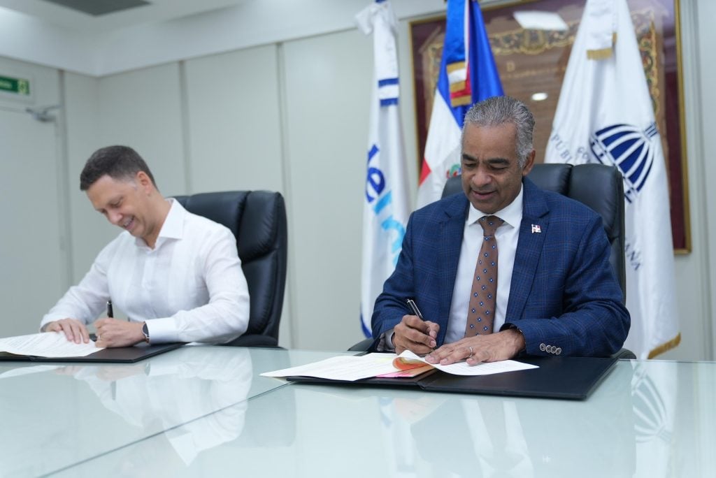 El ministro Joel Santos y el gerente general de Edenorte, durante la firma del acuerdo para la ejecución del proyecto de electrificación.